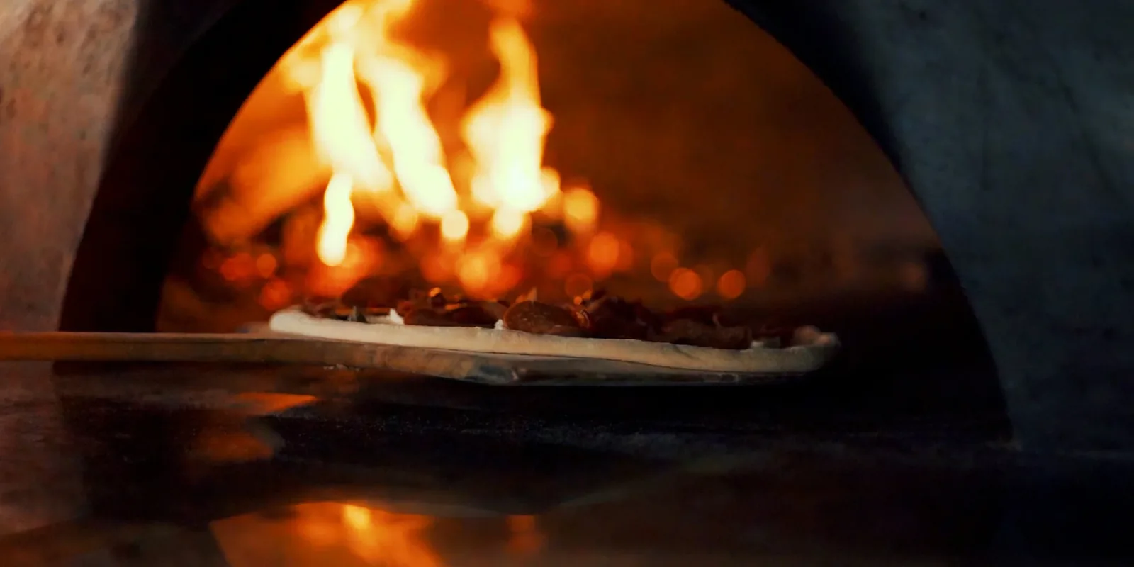 Flatbread cooking in a wood-fired oven at Wooden Paddle