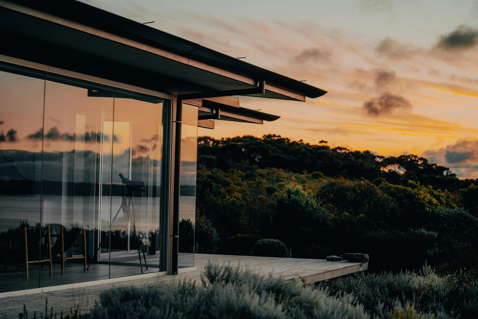 Modern house at sunset above a wooded landscape