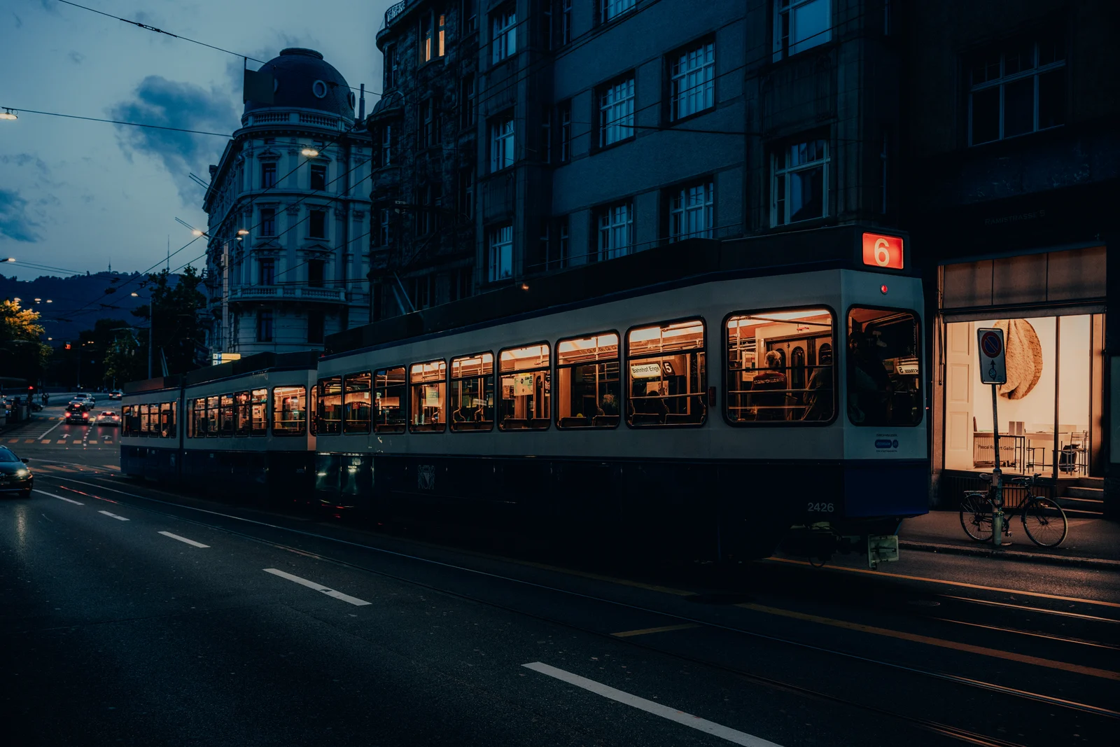 Tram moving through a blue-hour European street