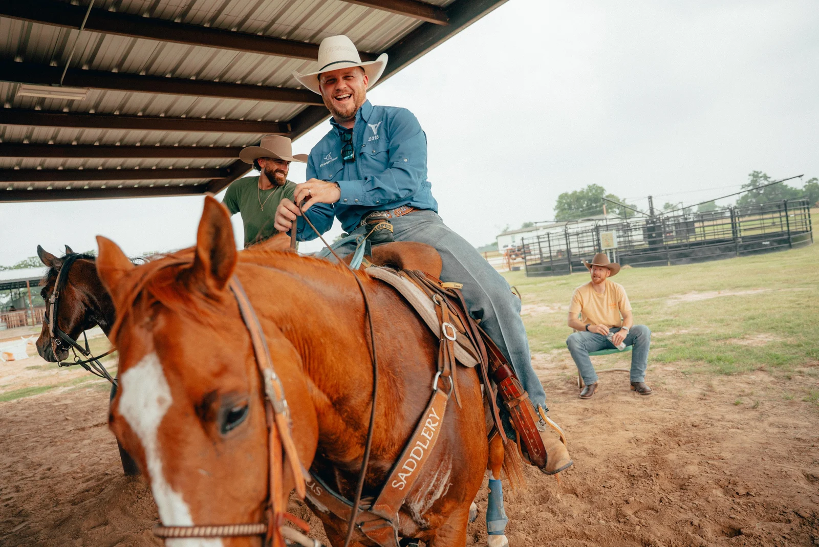 Cowboy riding a horse under a covered arena